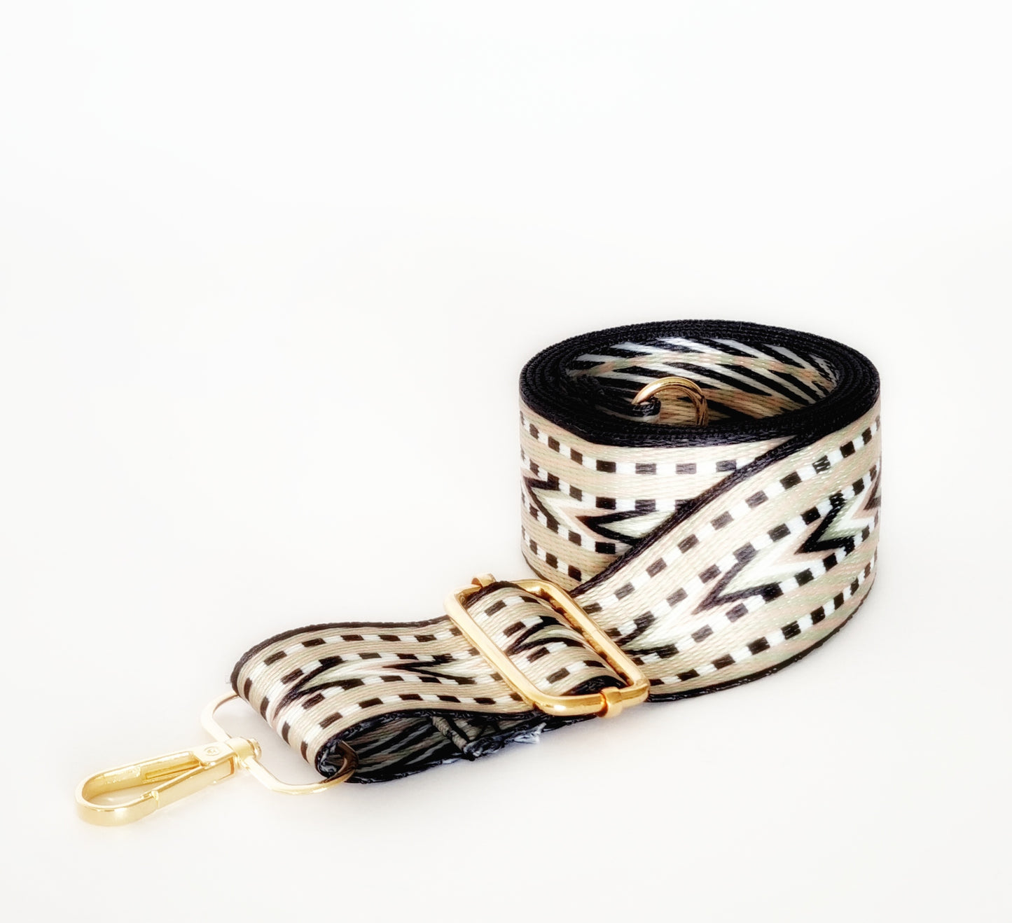 A black and platinum geometric patterned woven strap with gold hardware and a clip/hook enclosure, designed for bags.