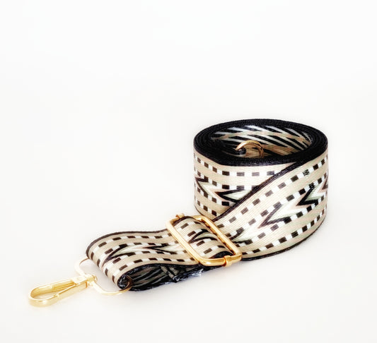 A black and platinum geometric patterned woven strap with gold hardware and a clip/hook enclosure, designed for bags.