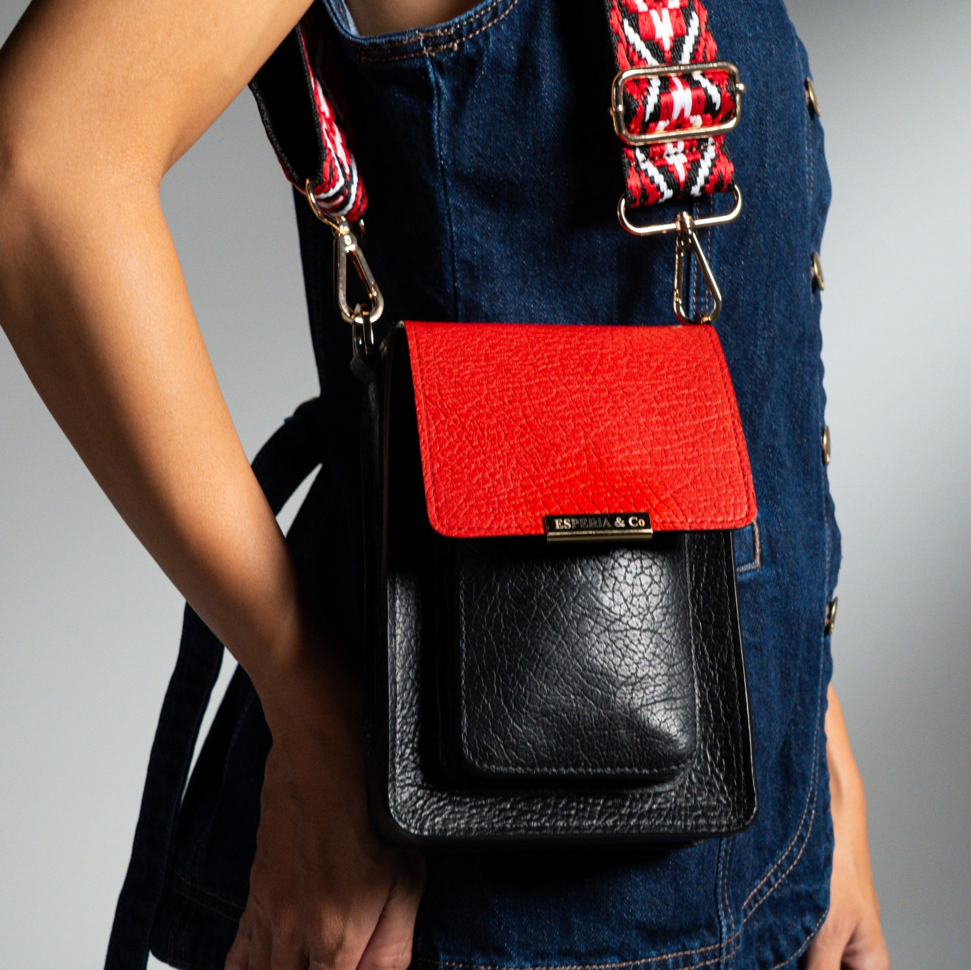 Black and red handbag with a visible brand name, worn over a person's shoulder 