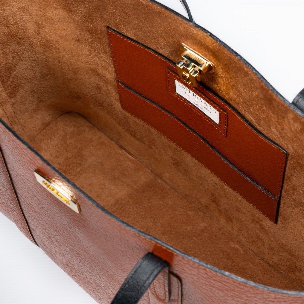 Close-up of a brown leather tote handbag with gold hardware 